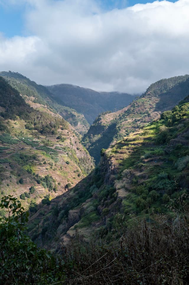Lush green valleys with mountains and cloudy sky